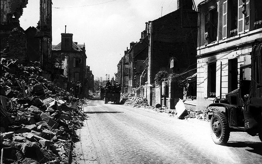 Members of the 1st Battalion, 355th Engineers, cleaning through wrecked streets of Saint-Lo so that traffic could move by road from Omaha beach.