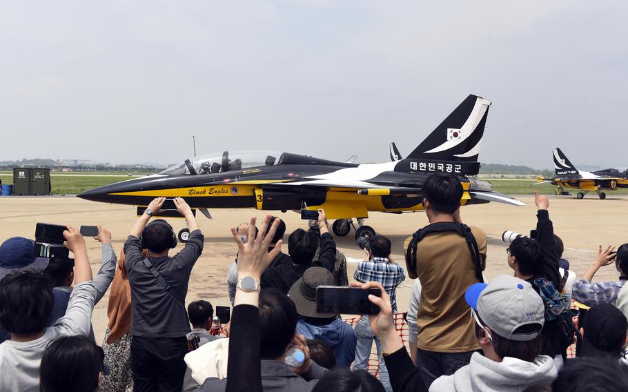 Spectators cheer as a Black Eagles taxi on the runway.