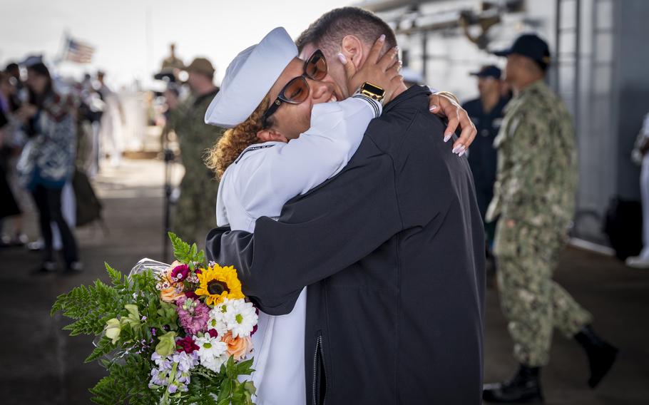A sailor embraces her partner