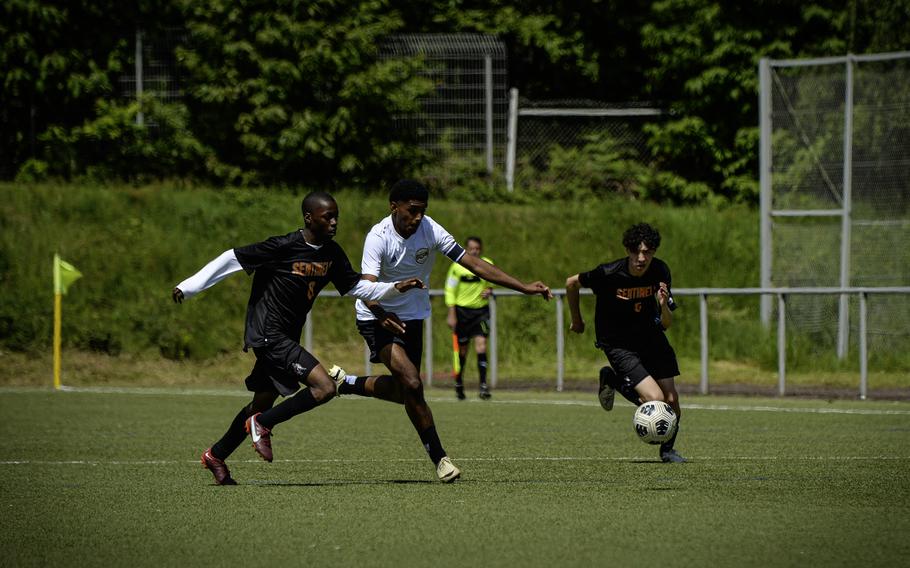 Baumholder’s Samuel Senatus runs past Spangdahlem defenders William Crofton, left, and Mason Tieyah during the 2024 DODEA European Soccer Division III Championships in Landstuhl, Germany, on May 20, 2024. Spangdahlem won 5-0.