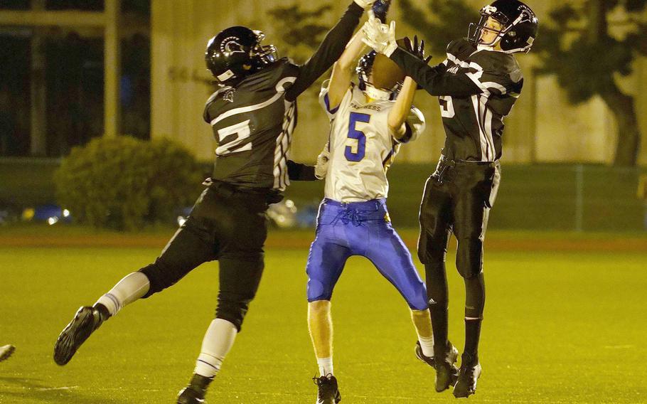 Zama American receivers Keshawn McNeill and Pierce Ingram and Yokota defensive back Michael Kasten go up for the ball.