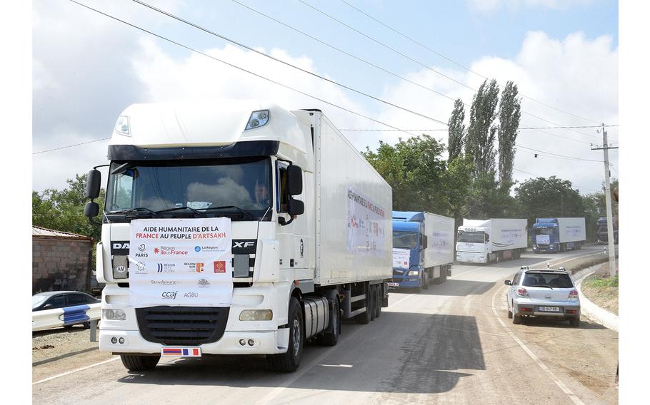 Lorries carrying French humanitarian aid for the Armenian-populated breakaway Nagorno-Karabakh region move through Kornidzor, a village on the border with Azerbaijan, on the way to the Lachin corridor, Karabakh's only land link with Armenia, on Aug. 30, 2023. 