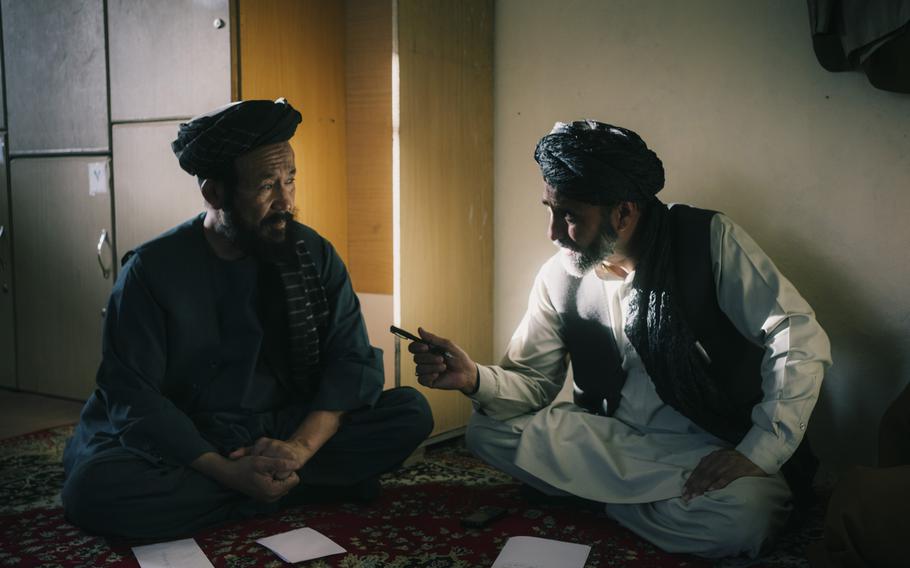 An employee and a Shiite elder discuss a case in a court in Kabul on Oct. 11, 2021.