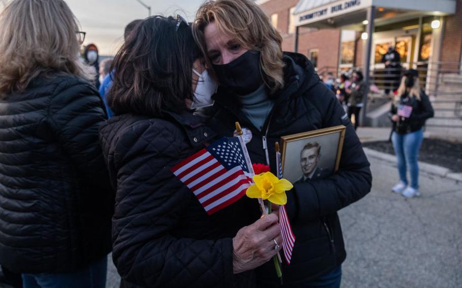 Roberta Weber-Twining (left) hugs Cheryl Turgeon during a vigil at the Soldiers' Home in Holyoke, Mass., on Tuesday, March 30, 2021. Turgeon's father, Korean War veteran Dennis Thresher, survived the coronavirus outbreak at the Soldiers’ Home in 2020 but died in January 2021. Weber-Twining's husband, Tim, is currently living at the Home. 