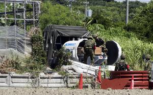 Japanese soldiers remove a U.S.-made, five-inch shell from an explosion-proof container after defusing it in Yaese, Okinawa, June 11, 2025.