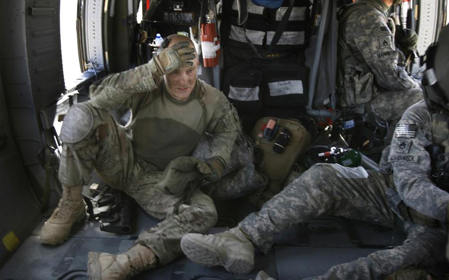 Sgt. 1st Class Jeff Johnson of Troop B, 4th Squadron, 4th Cavalry Regiment, 1st Heavy Brigade Combat Team, 1st Infantry Division, is transported by a medevac helicopter after suffering from traumatic brain injury following an improvised explosive device attack on June 20, 2011, near Pashmul South in Kandahar province, Afghanistan. 