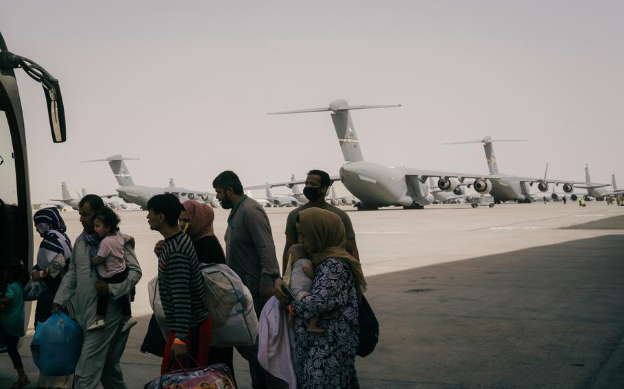 Afghan refugees board a bus at Al Udeid military base in Qatar - one of the main transit points for the evacuation of Afghans bound for the United States - on Aug. 31., 2021