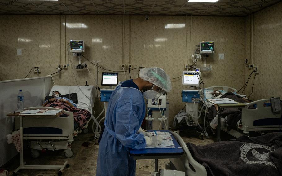 A medical worker checks on a covid-19 patient in the intensive care unit at al-Ziraa Hospital in Idlib, Syria, on Oct. 12, 2021. 