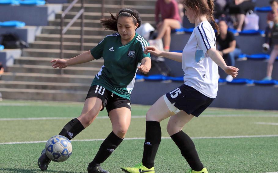 Daegu's Summer Brennan tries to pass around Osan's Halie Clark during Tuesday's DODEA-Korea soccer match. The Warriors won 4-3.