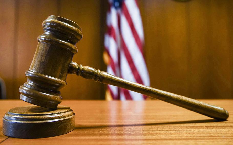 A closeup of a gavel on a courtroom desk.