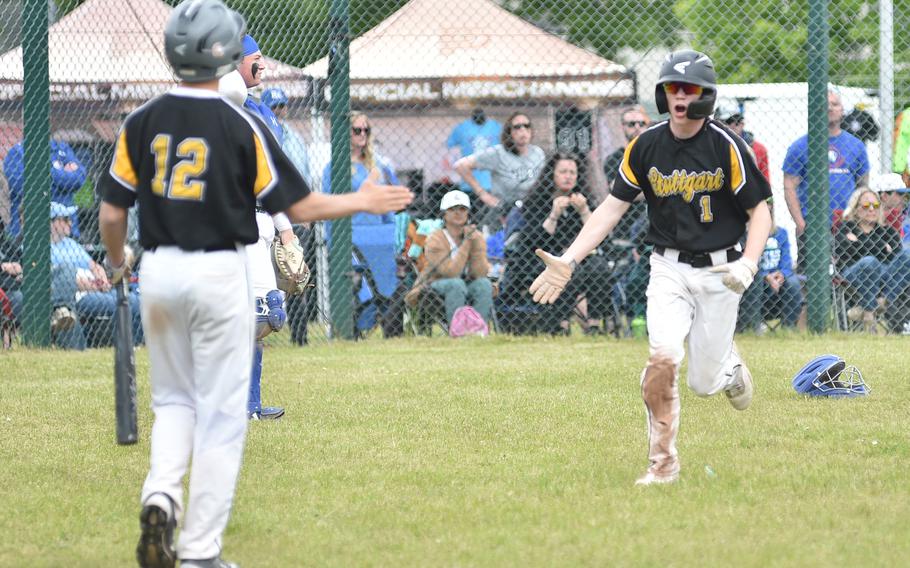 Stuttgart left fielder Josh Patrick, right, celebrates with teammate Tyler Blalock after scoring during the Division I DODEA European baseball championship game against Ramstein on May 20, 2023, at Southside Fitness Center on Ramstein Air Base, Germany.