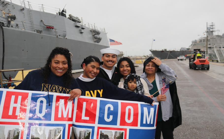Family and friends greet the crew of the USS Delbert D. Black with a sign welcoming them home, at Naval Station Mayport, Fla., Sunday, Feb. 18, 2024.