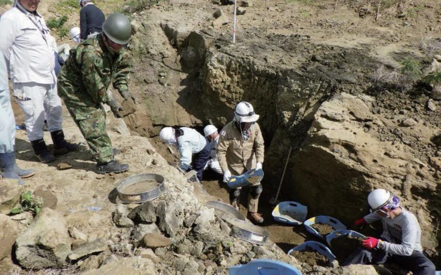 Personnel working for Japan's Ministry of Health, Labor and Welfare dig for remains from World War II in this undated photo. 