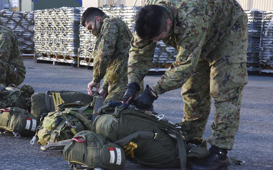 Troops from the Japan Ground Self-Defense Force prepare their parachuting gear at Yokota Air Base, Japan, ahead of jump on Thursday, Jan. 13, 2022.
