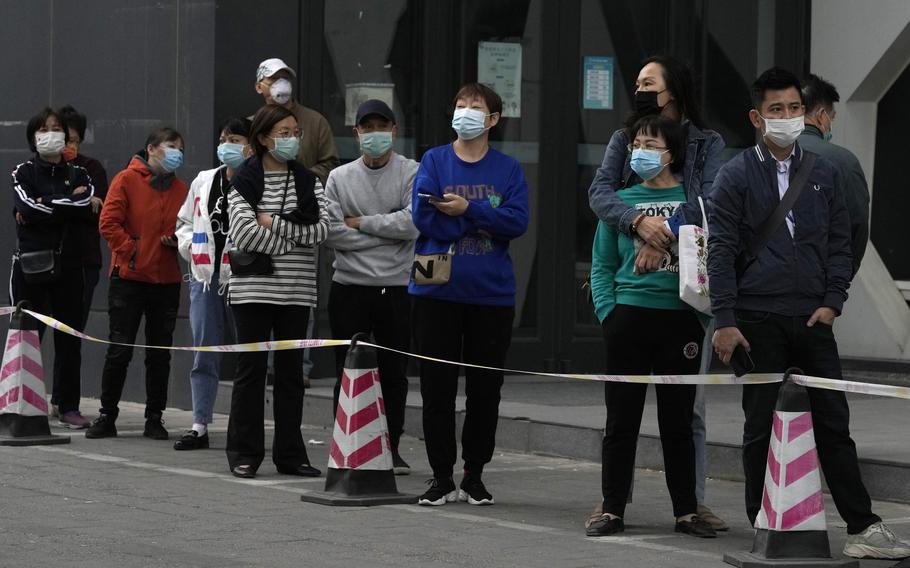 Residents line up for COVID-19 test, Wednesday, April 27, 2022, in Beijing. Workers put up fencing and police restricted who could leave a locked-down area in Beijing on Tuesday as authorities in the Chinese capital stepped up efforts to prevent a major COVID-19 outbreak like the one that has all but shut down the city of Shanghai.