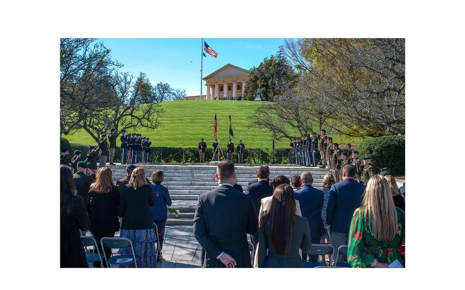 A crowd including military leaders, members of Congress, Army Green Berets and honor guard members stand and salute during the playing of the National Anthem at Arlington National Cemetery where a wreath laying ceremony was held on Nov. 8, 2023, to commemorate former President John F. Kennedy’s contributions to Special Forces. The ceremony took place at Arlington’s Eternal Flame, a memorial at JFK’s grave site. The former president was assassinated six decades ago on Nov. 22, 1963.