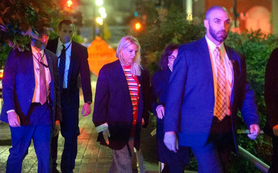 Attorney General Pam Bondi walks in a group past an orange construction sign.