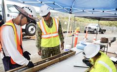 Navy contractors show Lt. Omar Vega-Campos core samples used for geologic analysis from a new groundwater monitoring well near the Red Hill well shaft in Aiea, Hawaii, July 26, 2022.
