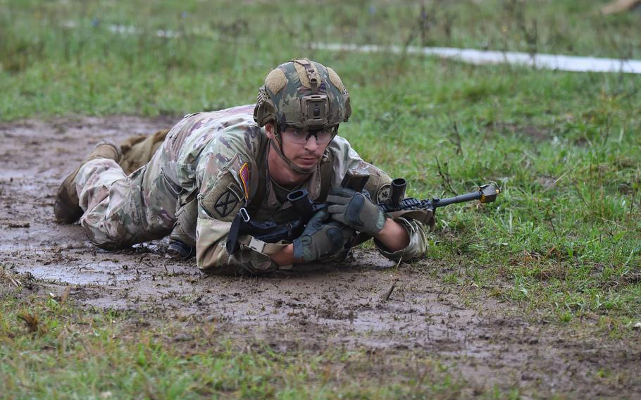 A soldier with the 2nd Cavalry Regiment low-crawls through the mud as part of Expert Infantryman Badge testing Sept. 14, 2022 at the Vilseck training area in Germany. The soldiers were on display as the African Land Forces Colloquium took a tour of the testing and training at the range. 