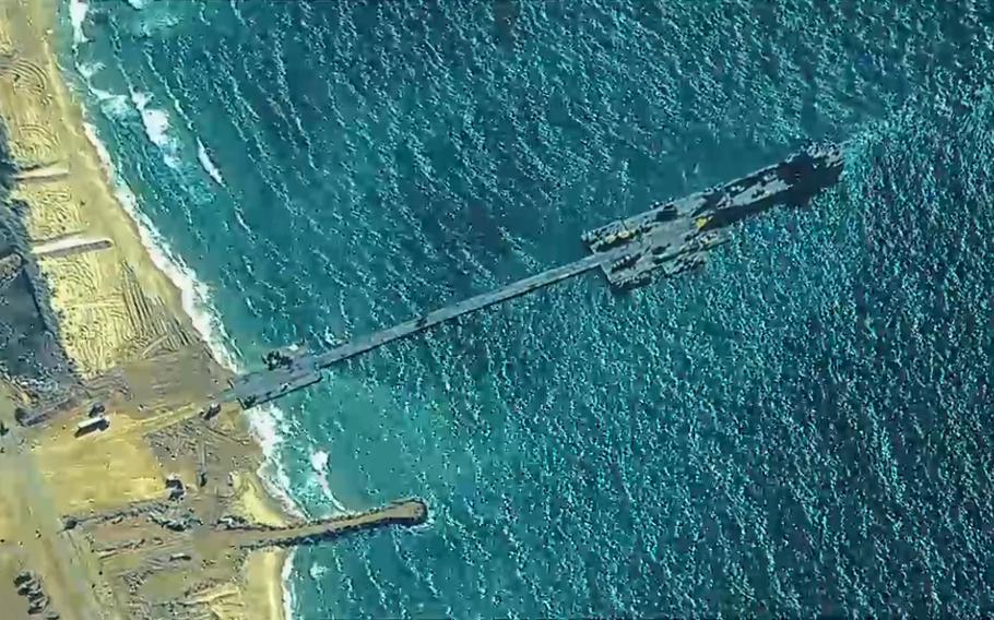 U.S. Army soldiers assigned to the 7th Transportation Brigade (Expeditionary), U.S. Navy sailors assigned to Amphibious Construction Battalion 1, and Israel Defense Forces install the Trident Pier on the Gaza coast, May 16, 2024. Humanitarian aid will start to move into the war-torn territory in the coming days, defense officials said.
