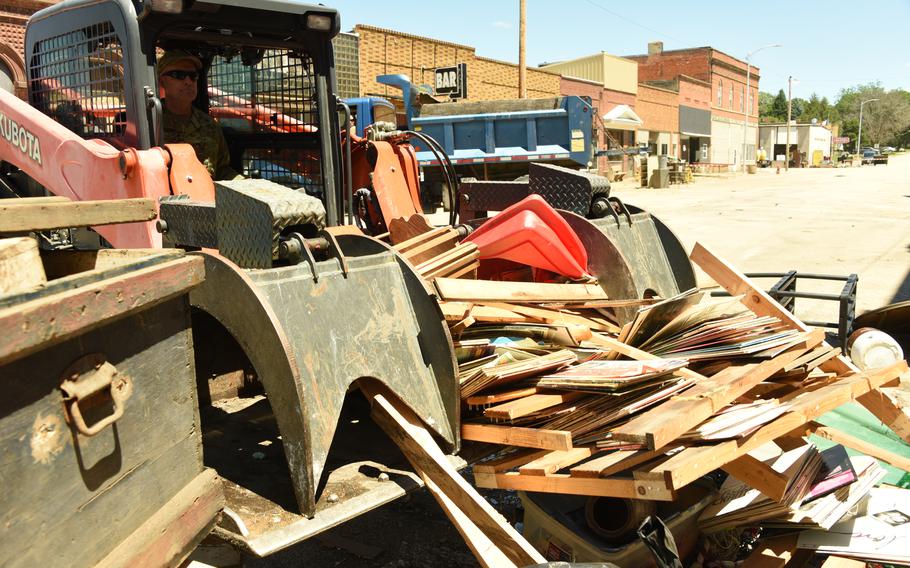 U.S. Air National Guard Chief Master Sgt. David Twohig operates a skid steer loader to clear debris in Sioux Rapids, Iowa, June 30, 2024. 