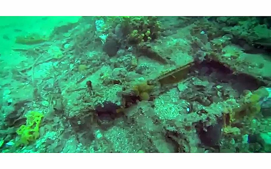 A video screen grab shows debris in an underwater landscape.