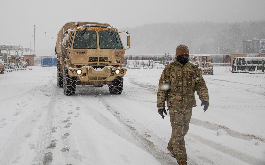 Cpl. Dante Price with 1st Battalion, 5th Field Artillery Regiment, 1st Armored Brigade Combat Team, 1st Infantry Division, guides a truck in Hohenfels, Germany, Nov. 30, 2021. The brigade's nine-month deployment to Europe has been extended, Army officials said.