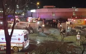 Image taken from a video showing ambulances and rescue teams staffers outside an immigration center in Ciudad Juarez, Mexico, Tuesday, March 28, 2023. 