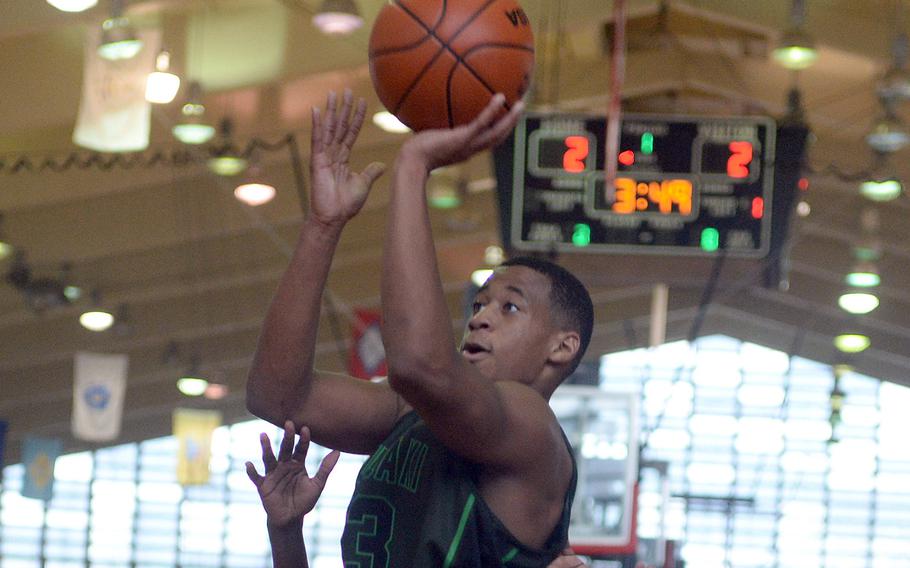 Kubasaki's T.J. Reese skies in the lane for a shot against Zion Christian during Saturday's pool-play game in the 16th Okinawa-American Friendship Basketball Tournament at the Camp Foster Field House. The Lions edged the Dragons 55-54.