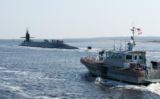 A U.S Coast Guard patrol boat, right, escorts the ballistic missile submarine USS Alaska  as the submarine returns to Naval Submarine Base Kings Bay, Ga., May 22, 2014.