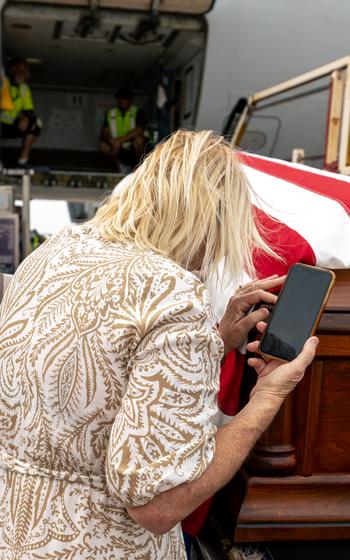 A family member leans over the casket.