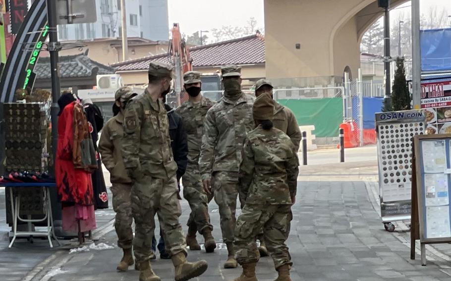 Service members wear face coverings as they stroll outside Osan Air Base, South Korea, earlier this month.