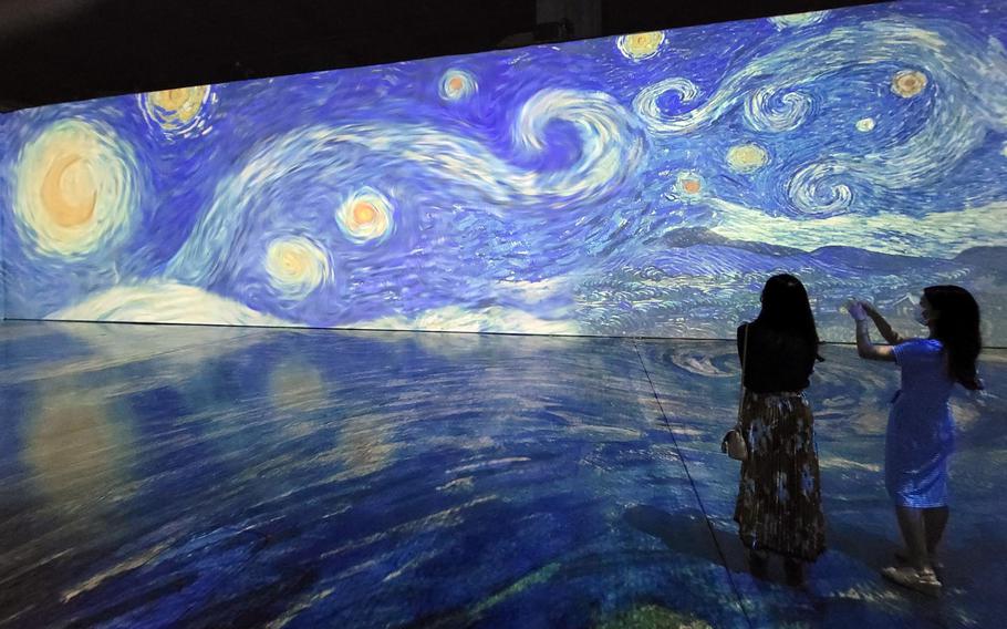 Visitors at Beyond Van Gogh: The Immersive Experience at the Honolulu Convention Center snap photos of the artist’s iconic painting, "The Starry Night."