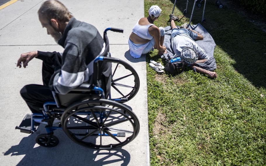 People displaced by Hurricane Ian hang out outside Hertz Arena, which is being used as a shelter, in Estero, Fla.