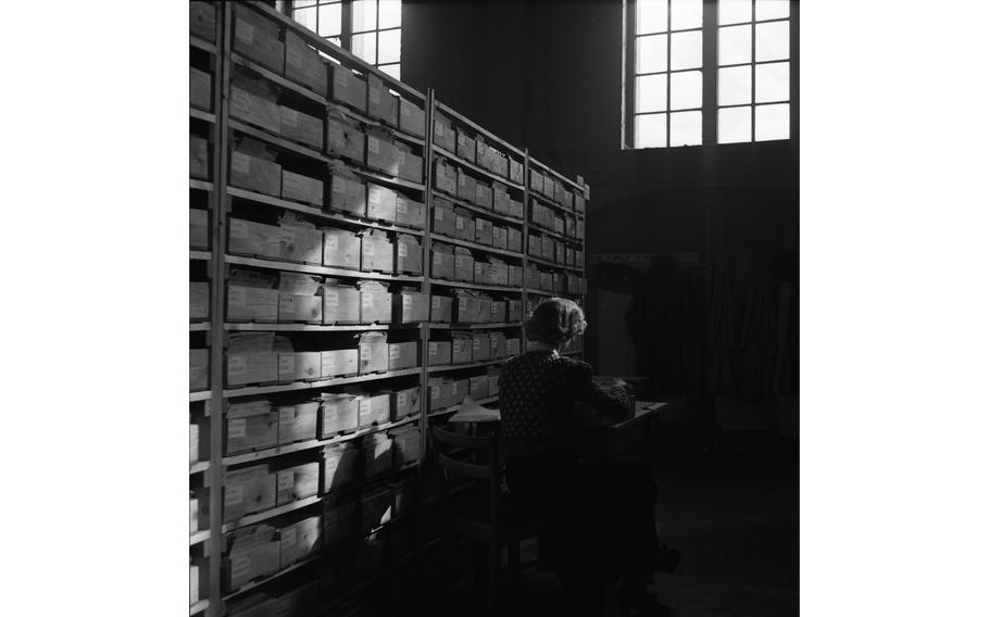 An investigator searches through the Child Search master index of some 204,000 cards, which include 70,750 birth certificates. The organization’s investigators search for non-German children separated from their families during the war.