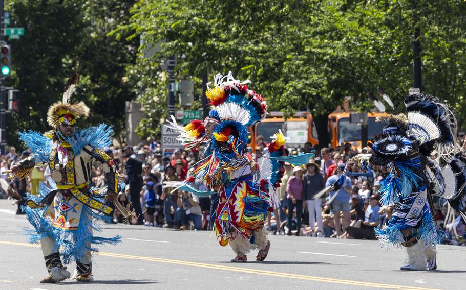 Performers dressed as Native Americans with colorful and elaborate headdresses. 