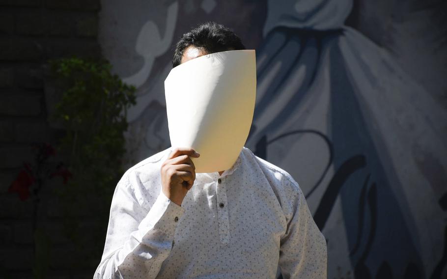An Afghan interpreter for U.S. forces hides his face as a result of threats against his life before he left Afghanistan in 2020 on a Special Immigrant Visa. The U.S. government must come up with a new plan to fix delays in the SIV program, which allows interpreters from Iraq and Afghanistan to resettle in the United States, after a federal judge rejected a government request to cancel the plan.