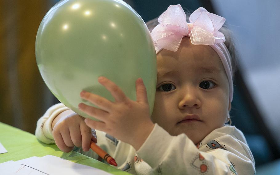 15-month old Omalbanin Hashimi poses for the camera at a baby shower for the Afghan women and their children living in the Philadelphia Residence Inn by Mariott, hosted by the Nationalities Service Center, in Philadelphia on Wednesday, Feb. 16, 2022.