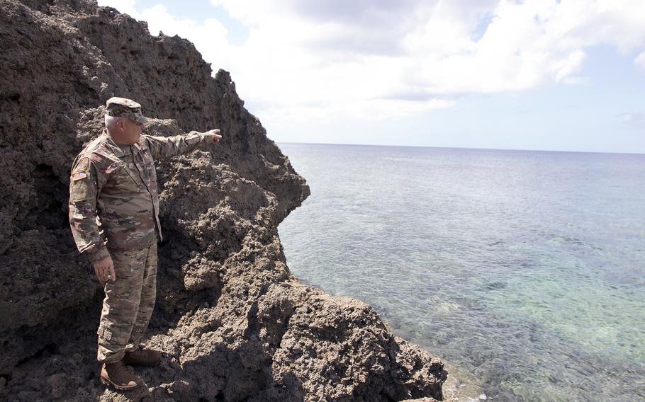 Army Maj. Robert Bourgeau points to the spot where he rescued three people from a riptide over the summer at Mermaid's Grotto in Onna, Okinawa, Oct. 3, 2022. 