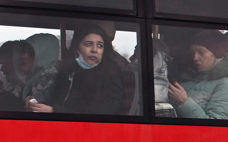 A refugee from Ukraine looks out the window as she rides from the Ukrainian-Polish border at Korczowa, Poland, to a nearby transit site for refugees, Feb. 27, 2022.