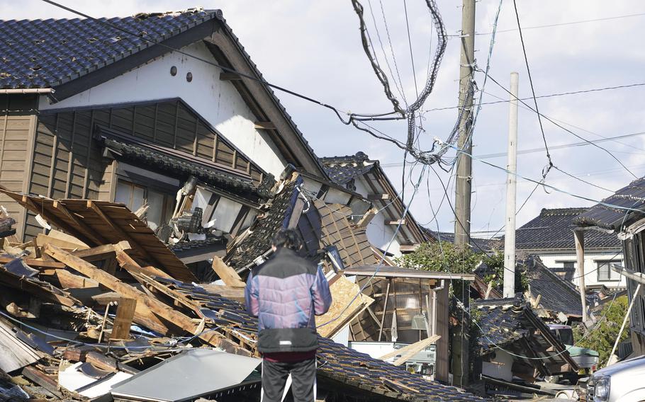 A man stands in front of a fallen house in Suzu, Ishikawa prefecture, on Jan. 4 following a series of earthquakes that struck Japan’s western coast.