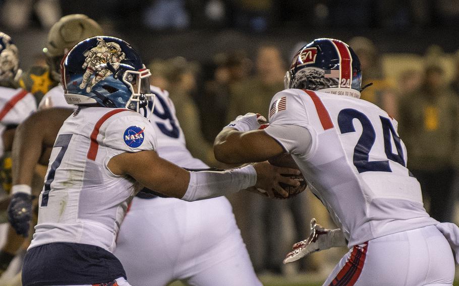 Navy slotback Maquel Haywood (24) takes a handoff from QB Xavier Arline (7) during the 123rd Army-Navy football game played at at Philadelphia’s Lincoln Financial Field on Saturday, Dec. 10, 2022. Army went on to beat Navy 20-17 in double overtime.