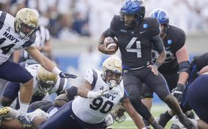 Air Force quarterback Haaziq Daniels evades Navy defensive lineman Donald Berniard Jr., center, and linebacker Colin Ramos for a short gain in the second half of an NCAA college football game Saturday, Oct. 1, 2022, at Air Force Academy, Colo.
