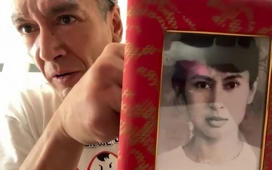 This video grab shows Kim Aris displaying an old family photo of his mother, Myanmar's ousted and detained leader Aung San Suu Kyi during an interview with The Associated Press in London, Wednesday, Sept. 13, 2023. Aris, Suu Kyi's younger son, expressed concern about the health of his mother, who was arrested when her government was toppled by the army in February 2021, remains in detention, apparently in a prison in the Myanmar capital Naypyitaw.