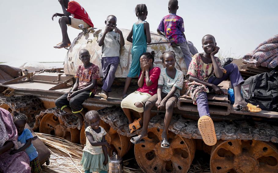 Children sit and play on the remains of a tank, at the river port in Renk, South Sudan Wednesday, May 17, 2023. Tens of thousands of South Sudanese are flocking home from neighboring Sudan, which erupted in violence last month. 