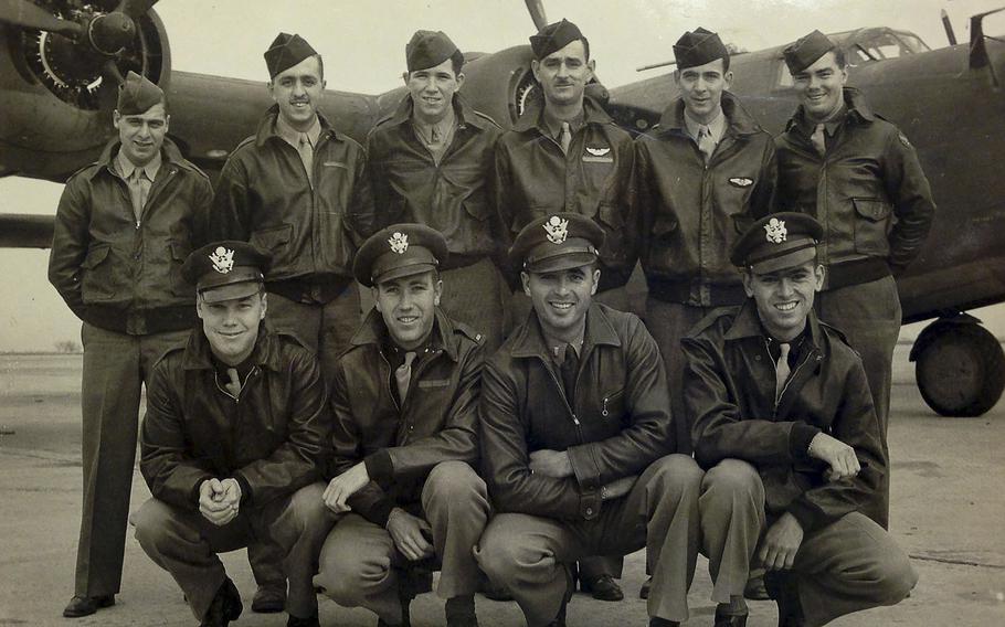 This black and white photo shows 10 of the 11 members of the crew of the World War II B-24 bomber, Heaven Can Wait, in front of the plane.