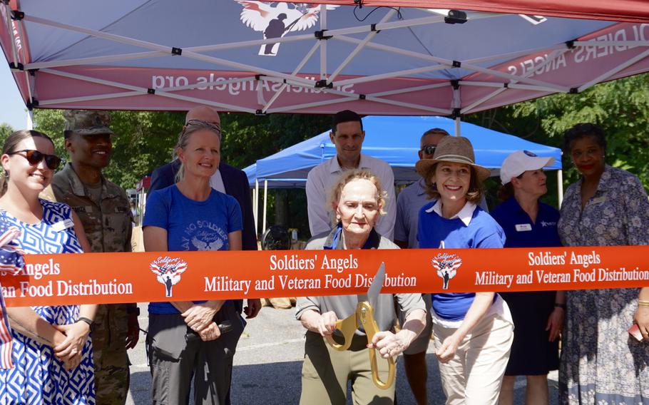 A woman cuts a ribbon with giant scissors