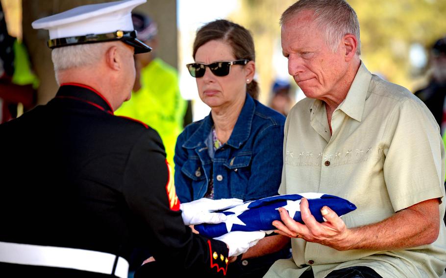 A member of the Honor Guard presents a folded American flag to Bob Blank on Thursday, March 24, 2022, during a funeral ceremony for World War II veteran George Brady, whose remains were interred at Riverside National Cemetery. Brady’s remains were found by Blank inside a storage unit in San Bernardino in February.
