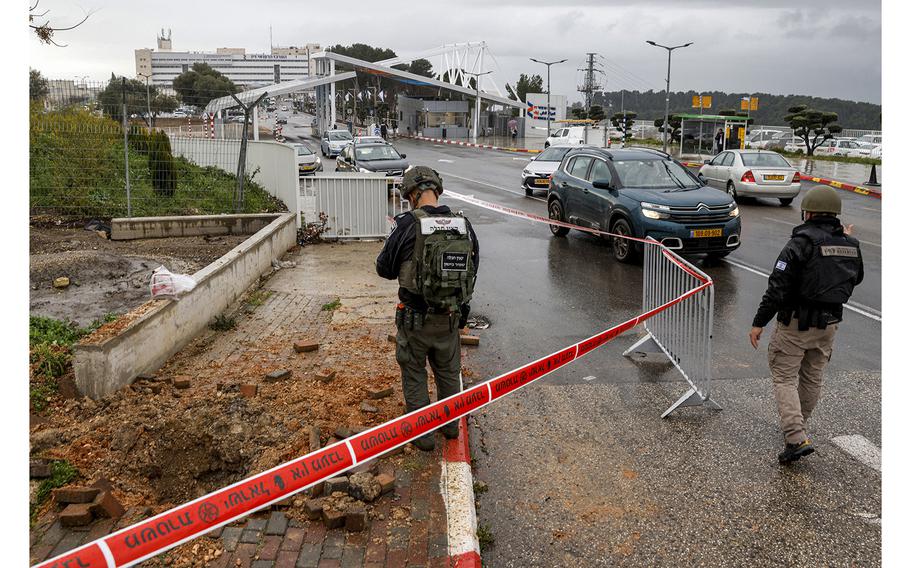 An Israeli policeman inspects the impact crater left by a rocket fired from southern Lebanon where it landed near the entrance of Ziv hospital in Israel's northern city of Safed on Feb. 14, 2024, amid ongoing cross-border tensions as fighting continues between Israel and Palestinian Hamas militants in the Gaza Strip. 