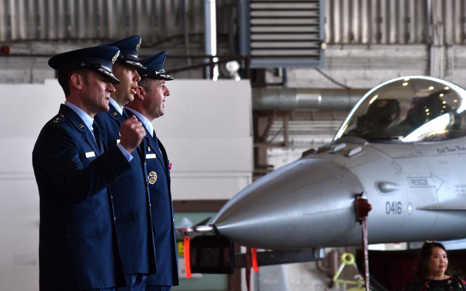 Men standing in front of an air craft.